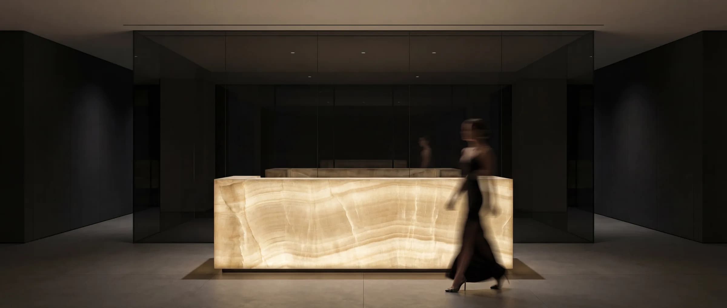 Monolithic onyx reception desk glowing under low light
